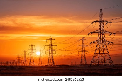 Sun setting behind the electric power lines running from Dungeness power station on the Kent coast south east England UK - Powered by Shutterstock