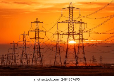 Sun setting behind the electric power lines running from Dungeness power station on the Kent coast south east England UK - Powered by Shutterstock