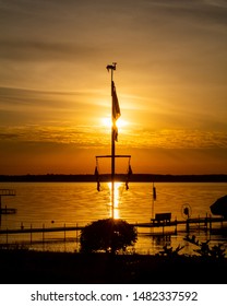 Sun Setting Behind a Flag Pole