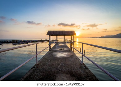 Sun setting behind the hut with smooth waves in the foreground