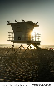 Sun setting behind a lifeguard tower on the beaches of Southern California