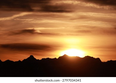The sun is setting behind a mountain range
