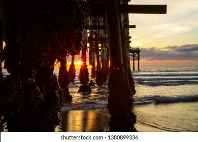 sun setting behind the pier