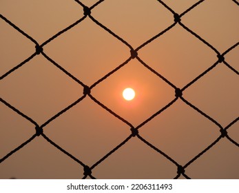 sun setting behind a security screen in a building window - Powered by Shutterstock
