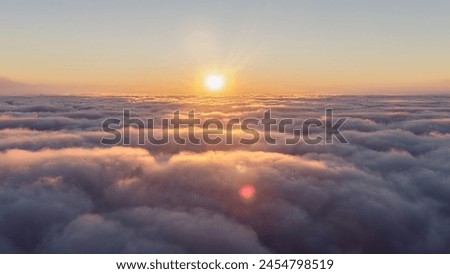 The sun is setting, casting a red glow over the clouds in the sky, creating a beautiful afterglow during dusk