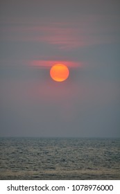 sun setting into the ocean
