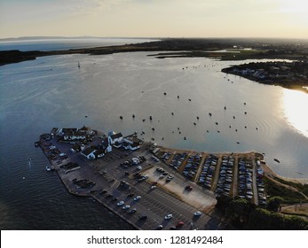 The Sun Setting Over Christchurch Harbour With Many Sail Boats Moored Up Enjoying The Last Rays