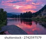 The sun is setting over the Clark Fork River in the town of Superior, Montana, USA