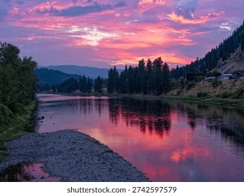 The sun is setting over the Clark Fork River in the town of Superior, Montana, USA