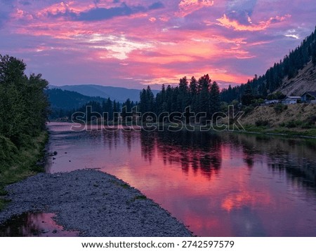 The sun is setting over the Clark Fork River in the town of Superior, Montana, USA
