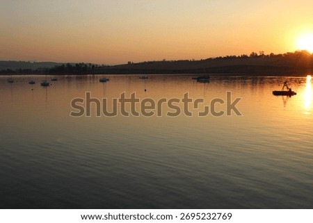 The sun setting over a dam 
