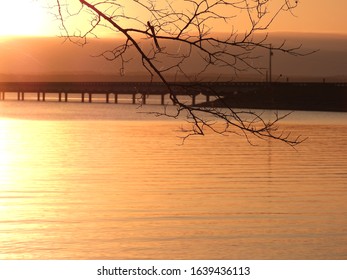 sun setting over lake with clouds