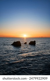 „The Sun Setting Over the Ocean Waters”