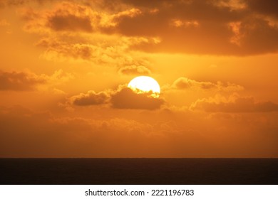 Sun setting over ocean with cloud