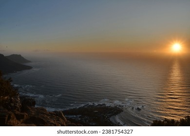 The sun setting over the ocean as seen from the top of the mountain