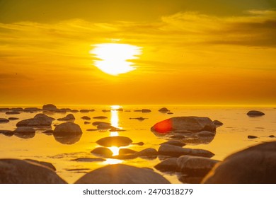 Sun is setting over the rocky pier to calm sea. Romantic view to stones in sea during sunset - Powered by Shutterstock