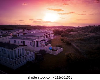 Sun Setting over the sea and Caravan and camping park, static home aerial view. Porthmadog holiday park taken from the air by a drone