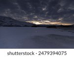 The Sun setting over snow-covered field