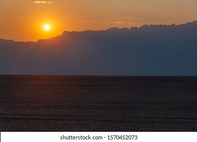 Sun setting over the Steens Mountains with the Alvord Desert in the foreground in Eastern Oregon