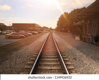 The sun setting over train tracks in historic downtown.