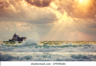 Sun setting at the sea with sailing cargo ship, scenic view