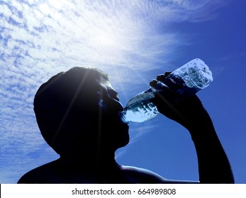 The Sun Shines On A Clear Day. It Makes The Weather Very Hot.A Man Was So Thirsty Because He Ran For A Long Time. He Is Drinking Bottled Water.