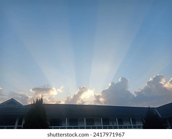 The sun shines through the clouds before setting.