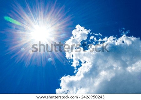 Sun shining brightly from behind clouds in the blue sky in Playa del Carmen Quintana Roo Mexico.