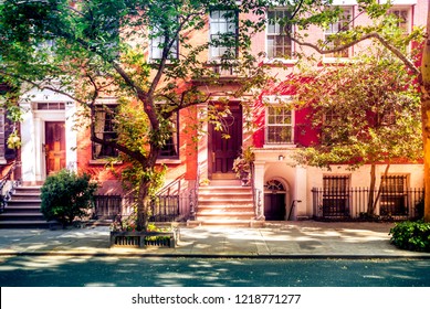Sun shining down on a beautiful street with brownstones in West Village, New York 