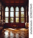 Sun shining into an old wooden room with high, beautiful windows and a single table in the center in a castle