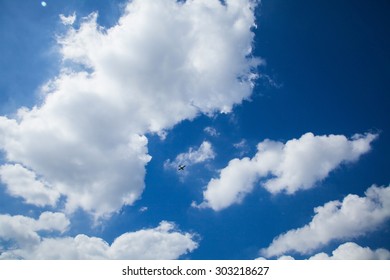 Sun shining on the sky with clouds and aircraft.