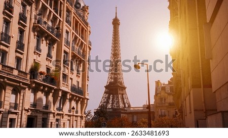 Sun shining over the Eiffel Tower framed by Parisian buildings at sunset