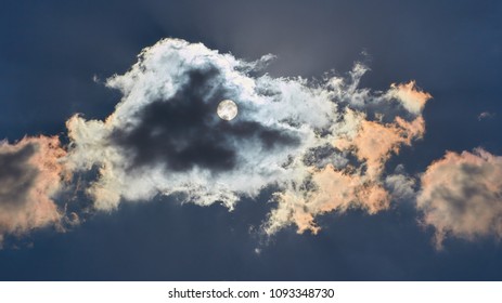 Sun shining through cloud with a blue sky in the background