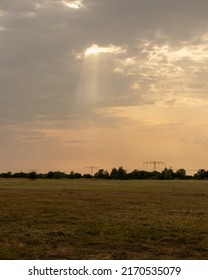 Sun shining through the clouds over a field 