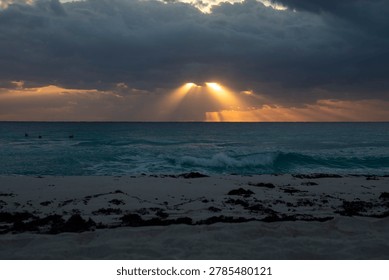 Sun shining through the clouds over the ocean on a winter morning in Cancun, Mexico.