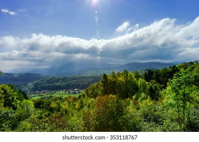 Sun shining through the clouds over beautiful green valley