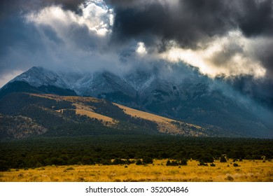 Sun shining through the dark clouds over the mountains Sand Dunes National Preserve Colorado