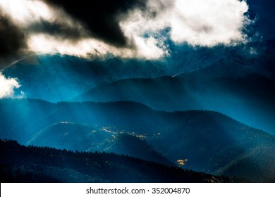 Sun shining through the dark clouds over the mountains Sand Dunes National Preserve Colorado