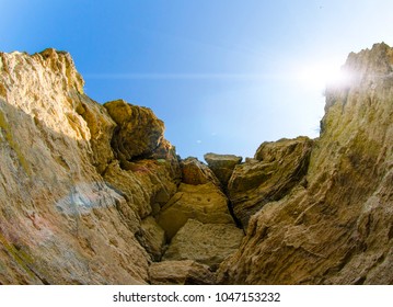 Sun shining through the edge of steep shore cliffs  with clear blue sky on a summer day.