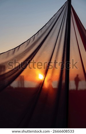 Sun shining through a light transparent veil. Artistic folds on fabric.