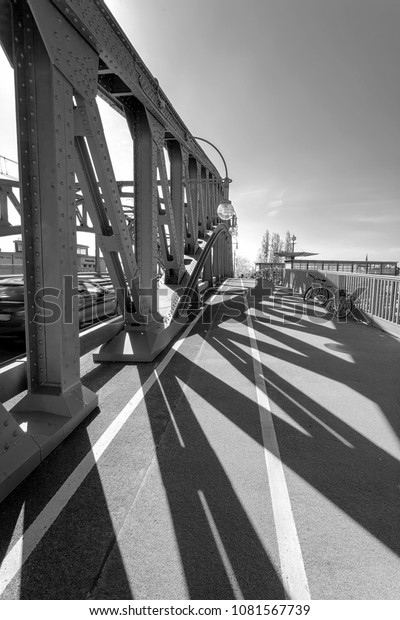 Sun shining through the pillars\
of a bridge, casting long shadows - Infrared black and\
white