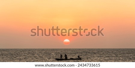 Sun sky in the evening over silhouette fishing boat on sea with big and bright on dusk sunset 