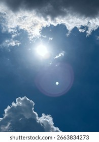 Sun In Sky Through Clouds In A Deep Blue Sky