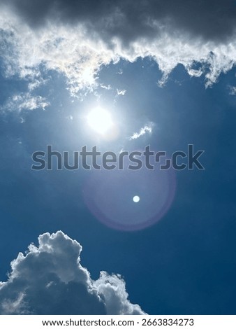 Sun In Sky Through Clouds In A Deep Blue Sky