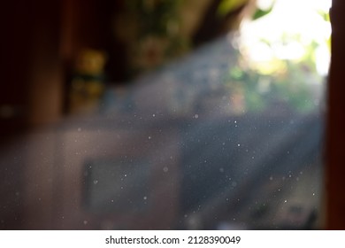 Sun spells by window with bright stream of light and visible particles indoors in room isolated. Clean room and dust in air concept - Shutterstock ID 2128390049