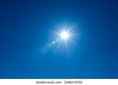Sun, sunbeams against blue sky - cloudless sky. Photography with Lense flair effect