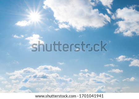 Sun with sunrays on the blue sky with white clouds. Daytime and good weather