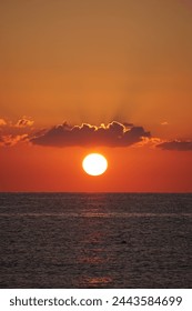 Sun at sunset between cloud and sea