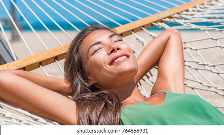 Sun Tan Sleeping Woman On Beach Hammock On Caribbean Tropical Vacation Getaway. Zen Wellness Asian Girl Relaxing Smiling Happy At Outdoor Hotel.