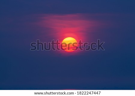 The sun that sets in the clouds at sunset.